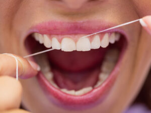 mulher passando fio dental